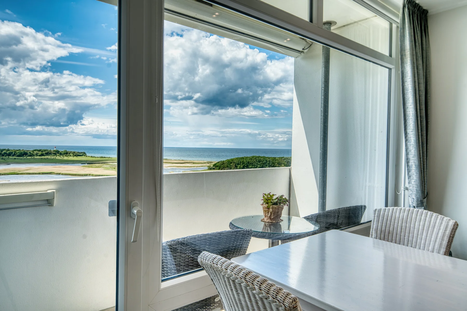 Blick vom Essbereich durch die offene Balkontür auf die Ostsee